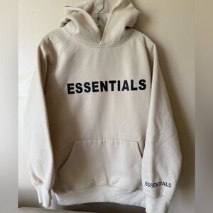 Cream Hoodie with Essentials on the front, sleeve and hood